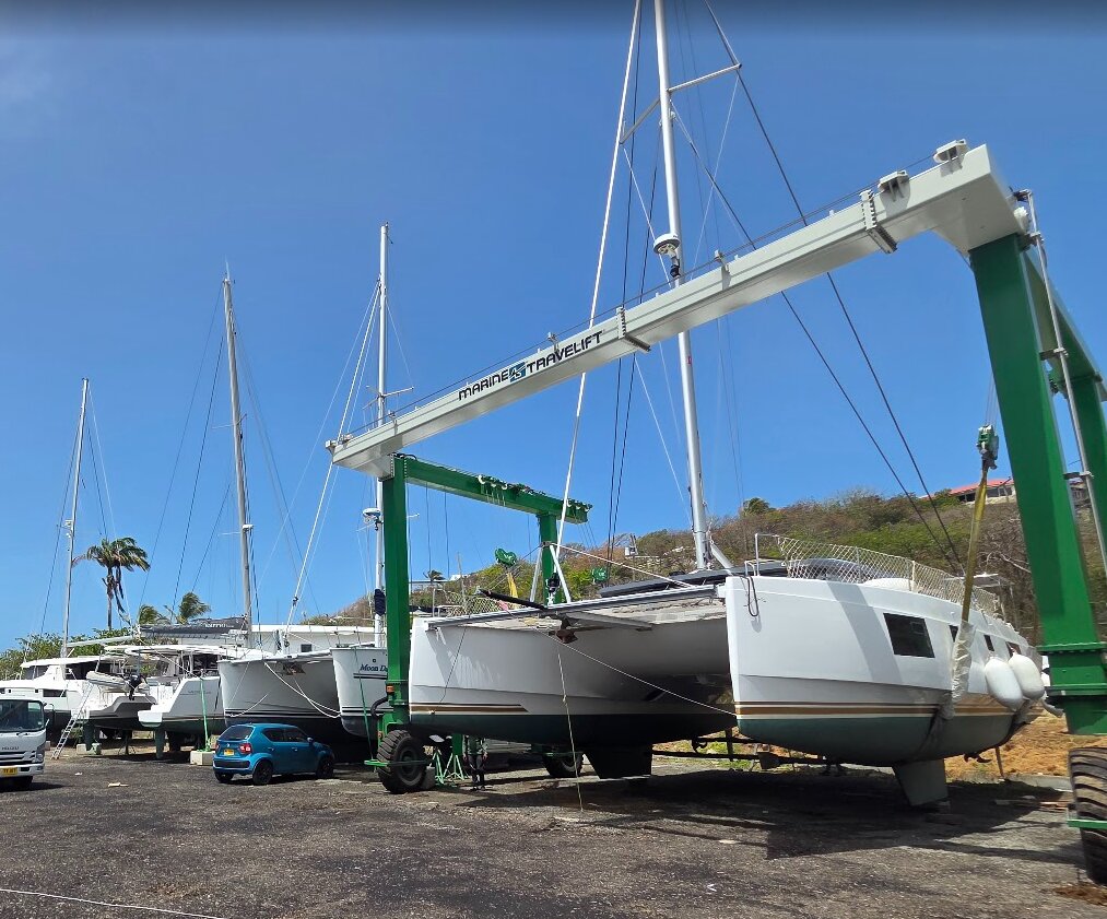Courage hauled out on a travel lift at the boatyard, alongside other catamarans