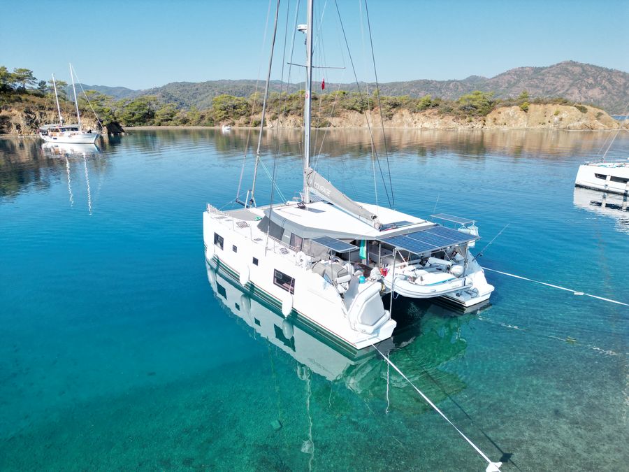 Aerial view of Courage anchored near a rocky point