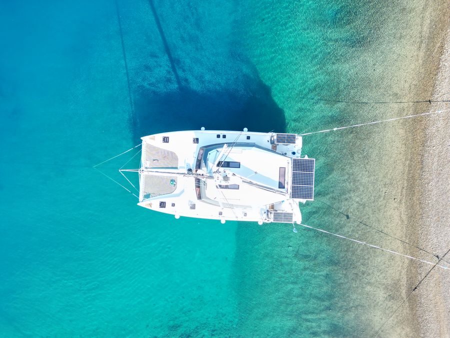 Aerial view of Courage anchored in a turquoise cove