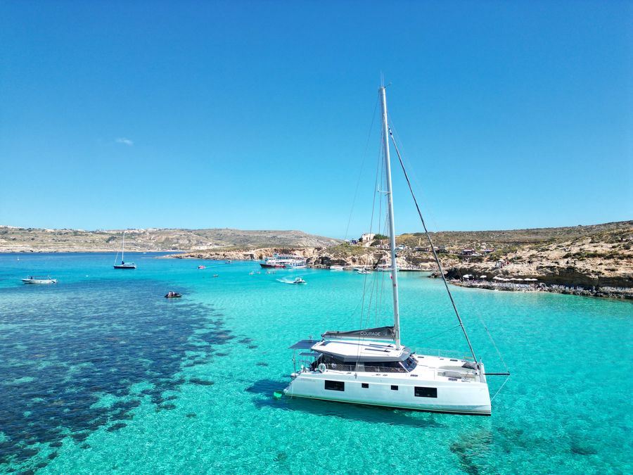 Aerial view of Courage anchored in clear turquoise water