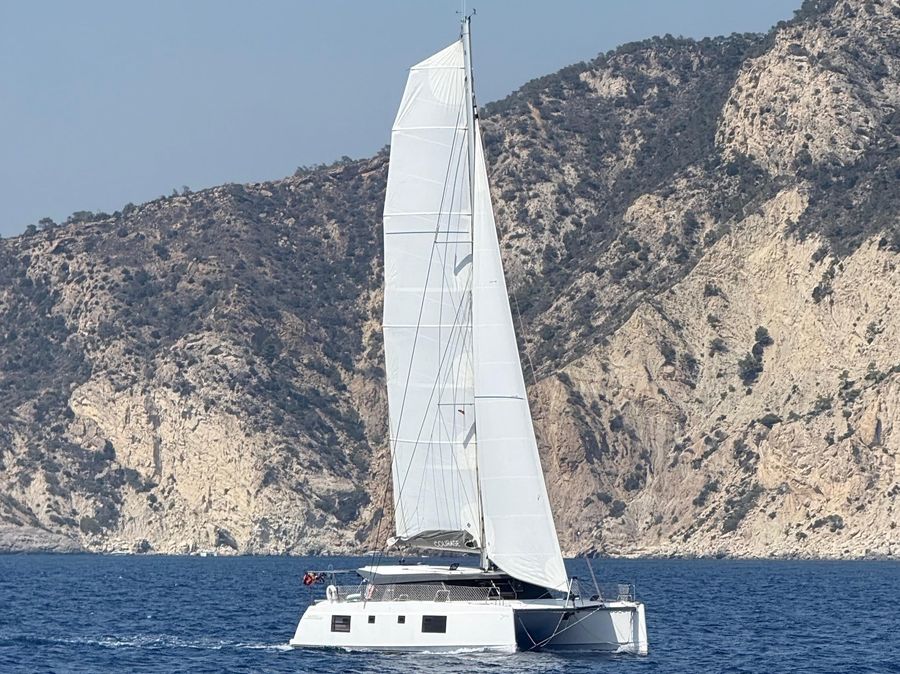 Courage sailing near a rocky coastline