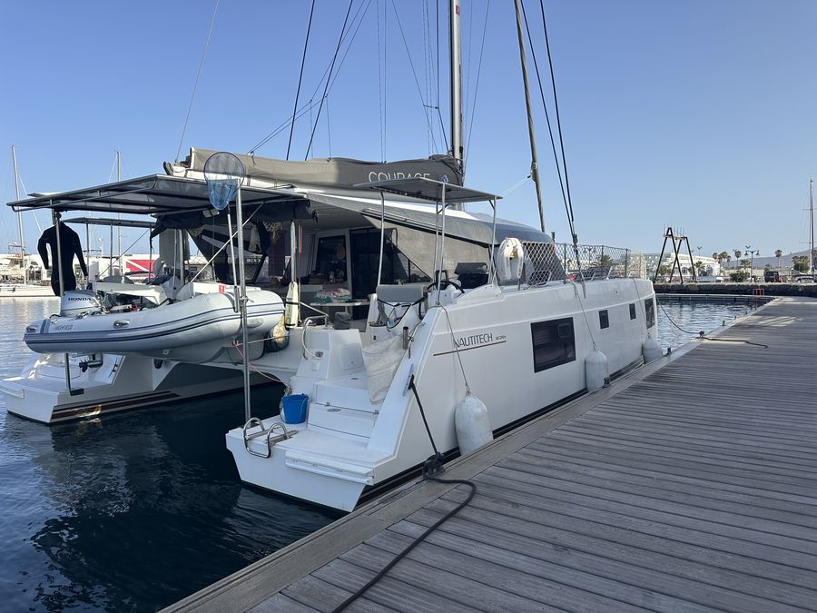 Courage stern-to at the dock with tender on davits