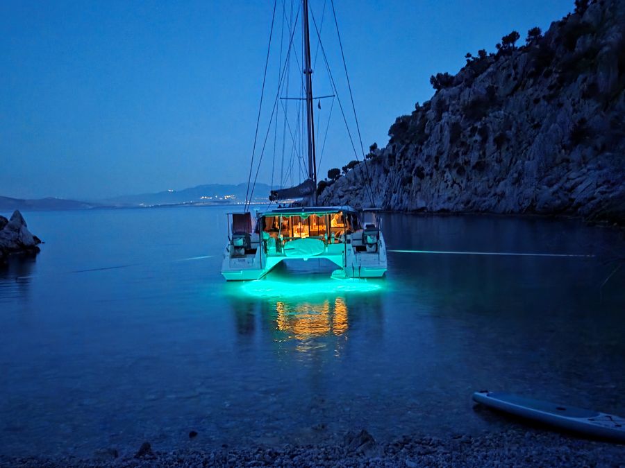 Courage at anchor at night, underwater lights glowing