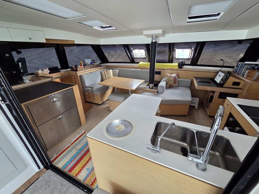 Galley island with sink and fridge/freezer drawers, saloon beyond